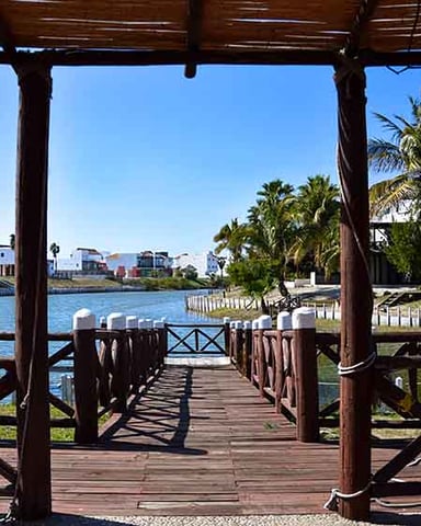 Entrada al puerto de Mazatlán al atardecer con boya de navegación roja y cielo naranja cálido